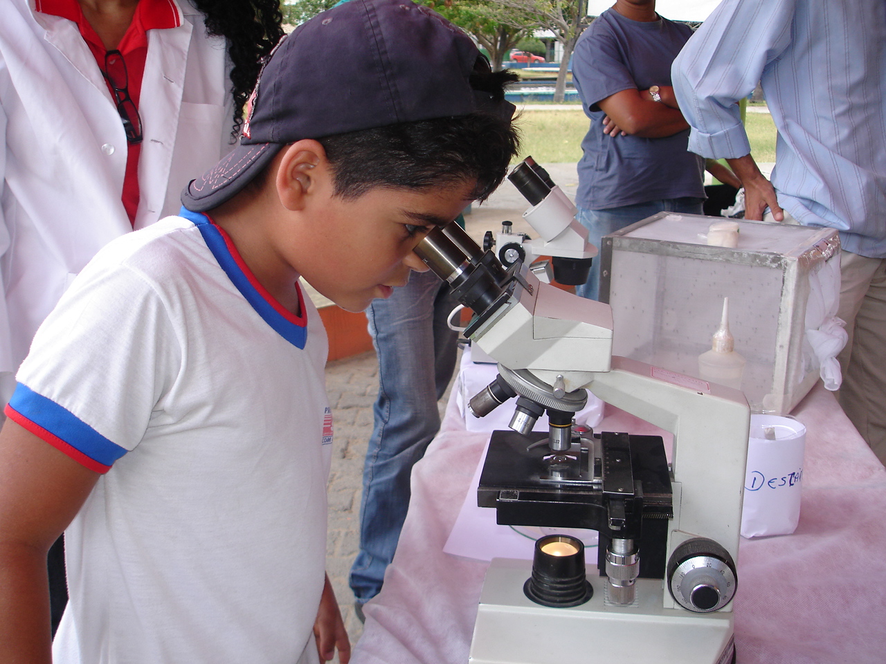 Menino observa no microscópio