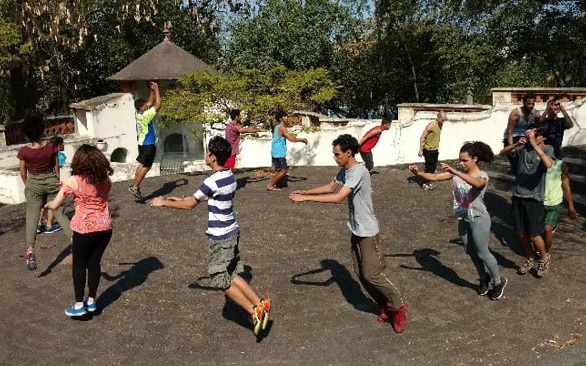 Adolescentes fazendo atividades em um círculo, no pátio do Pombal