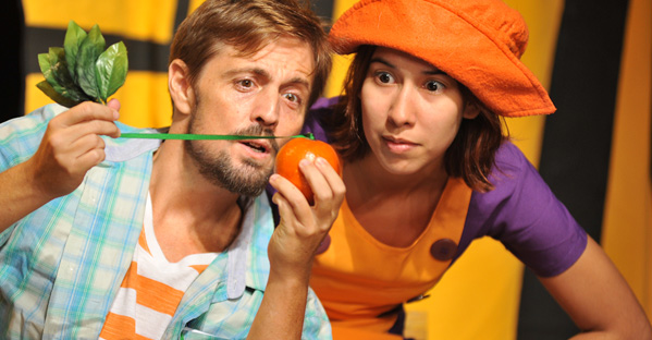 Homem e mulher interagindo com uma laranja