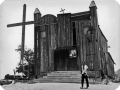 Homem em frente a igreja de madeira