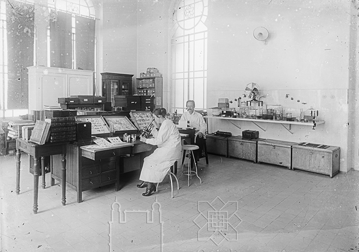 Adolpho e Bertha Lutz sentadoa à mesa de trabalho no laboratório